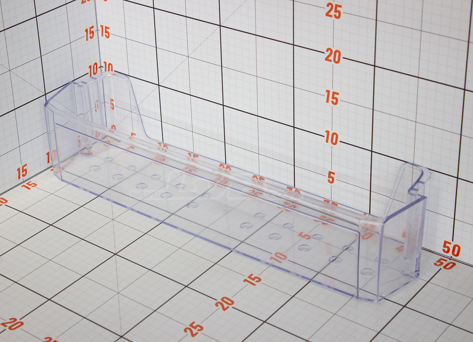 Clear plastic tray with measurement markings on a grid background