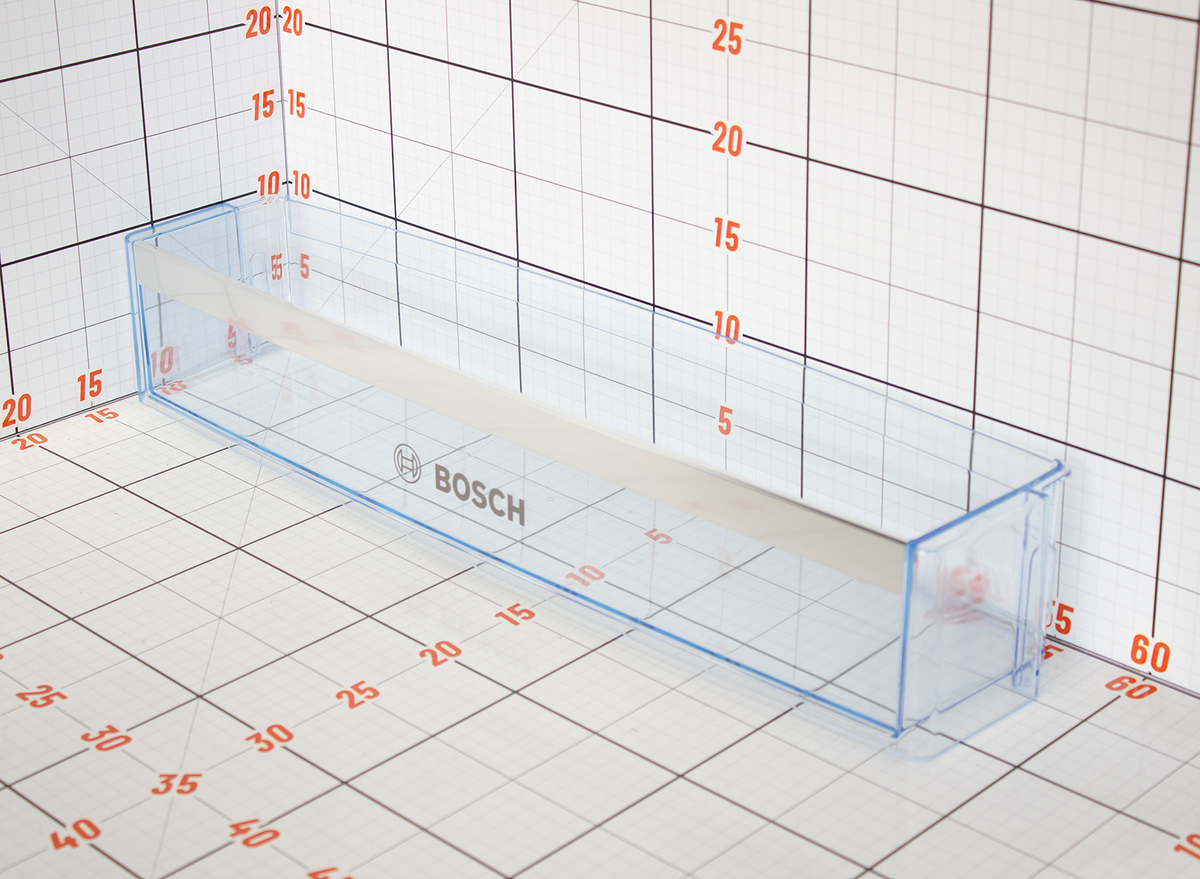 Clear plastic measuring tool with Bosch branding on a grid background