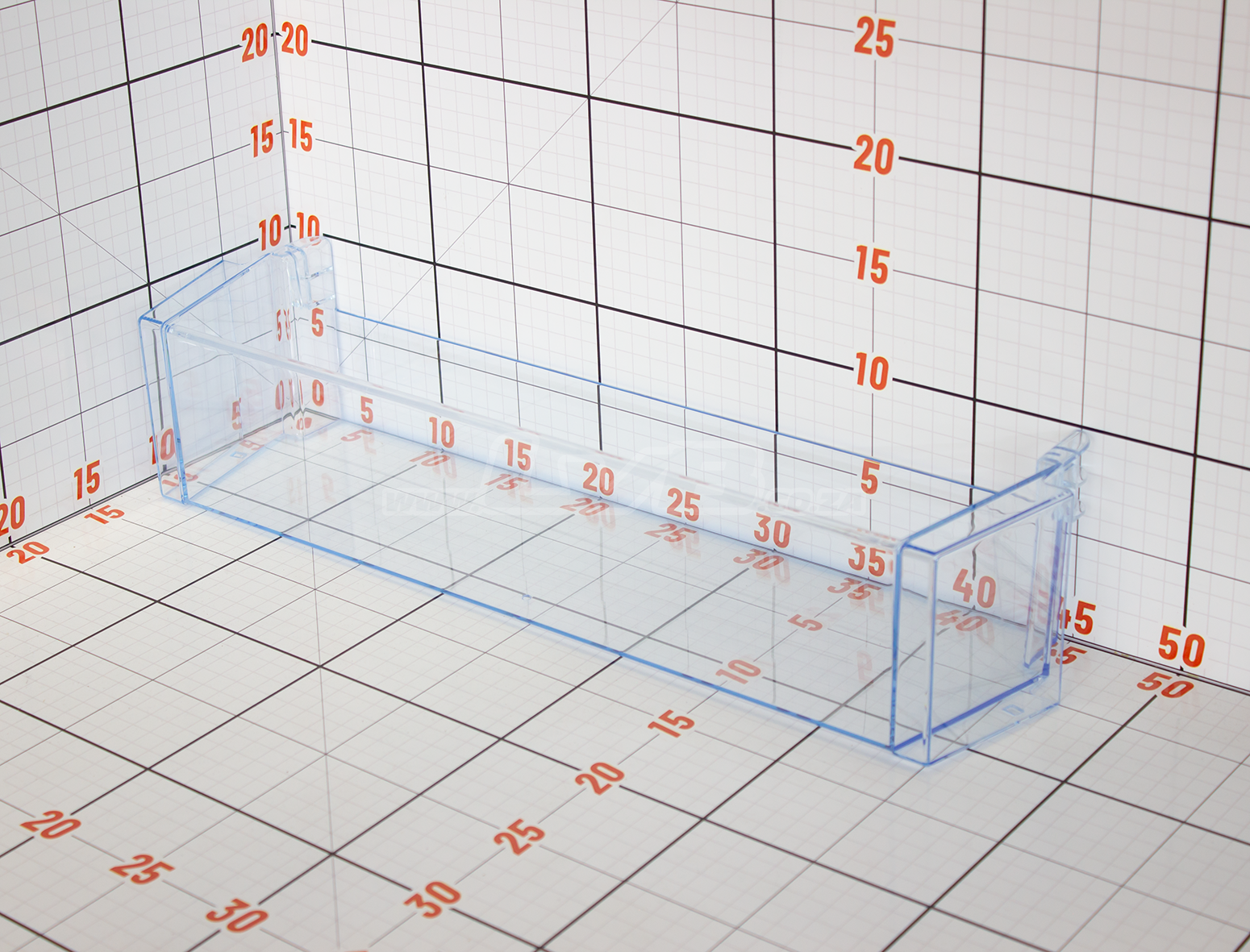 Clear plastic rectangular container with measurement markings on a grid background
