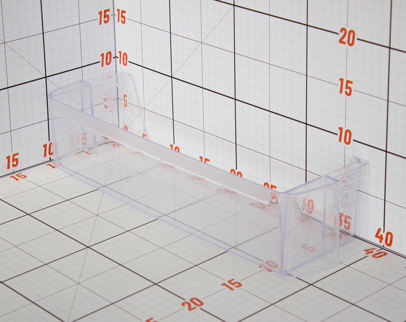 Clear acrylic block with measurement markings on a grid background
